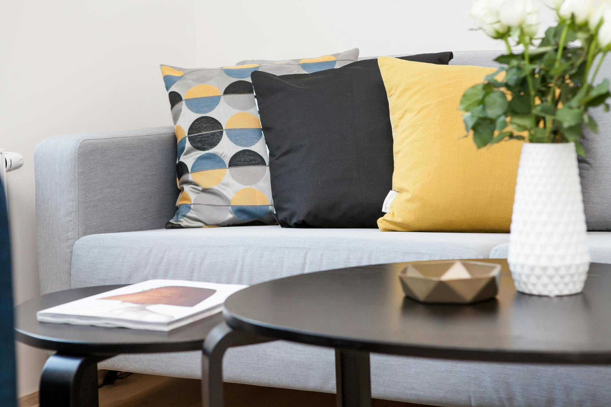 What Professional Steam Cleaning Actually Removes That Regular Cleaning Leaves Behind Contemporary living room interior featuring a stylish sofa, decorative pillows, and a vase of flowers.